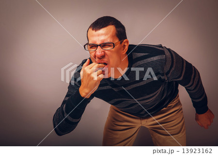 the man of European appearance brunet in a sweater put his finge the man of European appearance brunet in a sweater put his finge 13923162