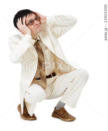 Scared young man in white suit sits 13924300