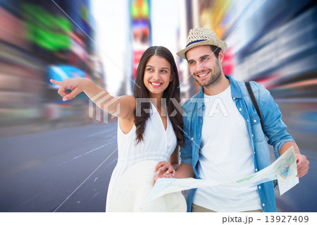 Composite image of happy hipster couple looking at map 13927409