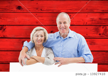 Composite image of mature couple smiling at camera Composite image of mature couple smiling at camera 13927410