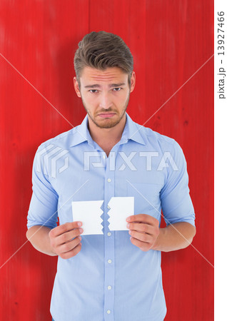Composite image of sad man holding a broken card Composite image of sad man holding a broken card 13927466