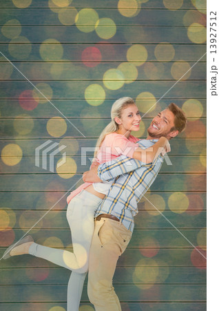 Composite image of handsome man picking up and hugging his girlf Composite image of handsome man picking up and hugging his girlf 13927512