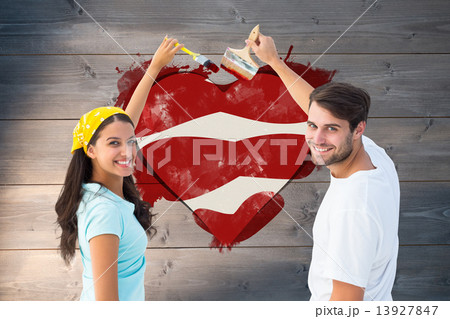 Composite image of happy young couple painting together Composite image of happy young couple painting together 13927847