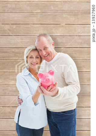 Composite image of happy mature couple smiling at camera showing Composite image of happy mature couple smiling at camera showing 13927960