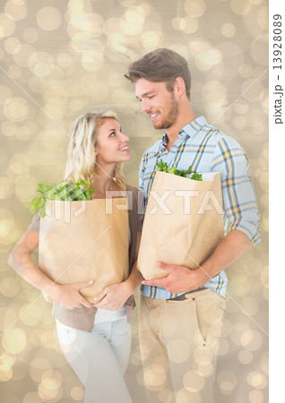 Composite image of attractive couple holding their grocery bags 13928089