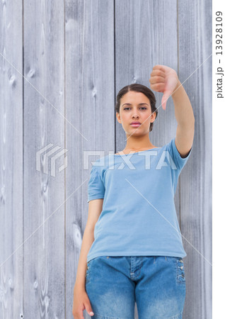 Composite image of pretty brunette giving thumbs down Composite image of pretty brunette giving thumbs down 13928109