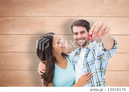 Composite image of happy young couple showing new house key 13928170