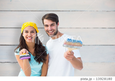 Composite image of happy young couple painting together Composite image of happy young couple painting together 13928180
