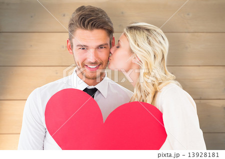Composite image of attractive young couple holding red heart 13928181