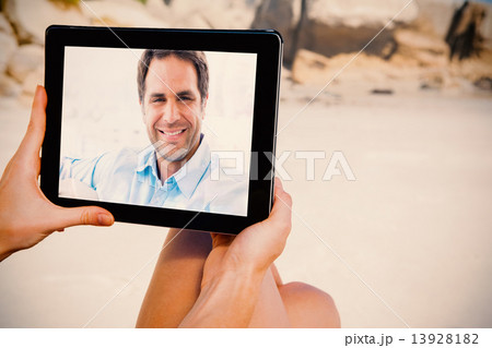 Composite image of smiling handsome man sitting on the couch loo 13928182