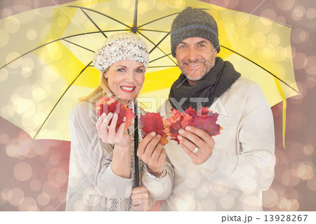 Composite image of couple in winter fashion showing autumn leave Composite image of couple in winter fashion showing autumn leave 13928267