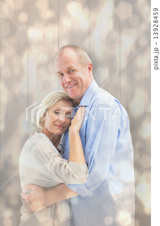 Composite image of happy mature couple hugging and smiling 13928459