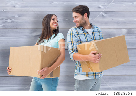 Composite image of happy young couple with moving boxes Composite image of happy young couple with moving boxes 13928558