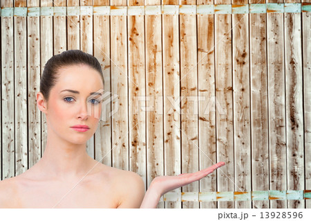 Composite image of beautiful brunette presenting with hand Composite image of beautiful brunette presenting with hand 13928596