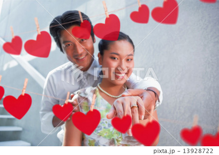 Composite image of couple showing engagement ring on womans fing 13928722