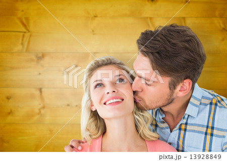Composite image of handsome man kissing girlfriend on cheek 13928849