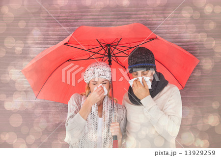 Composite image of couple in winter fashion sneezing under umbre Composite image of couple in winter fashion sneezing under umbre 13929259
