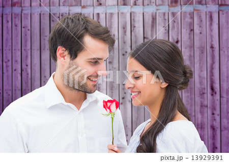 Composite image of handsome man offering his girlfriend a rose Composite image of handsome man offering his girlfriend a rose 13929391