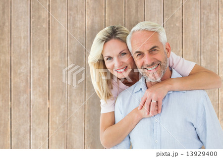 Composite image of smiling couple embracing and looking at camer 13929400