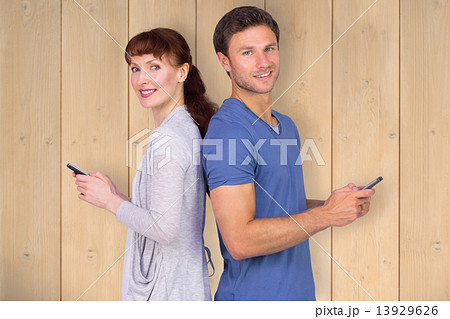 Composite image of couple both sending text messages Composite image of couple both sending text messages 13929626