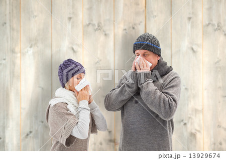 Composite image of sick mature couple blowing their noses Composite image of sick mature couple blowing their noses 13929674