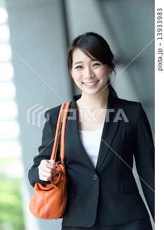 One young successful Chinese businesswoman walking along office building walkway 13933983