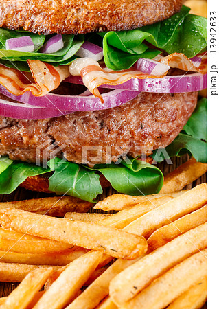 Burger and french fries close up on wooden background. Burger and french fries close up on wooden background. 13942633