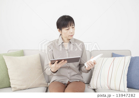 タブレットと化粧品を手にするミドルの女性 タブレットと化粧品を手にするミドルの女性 13947282