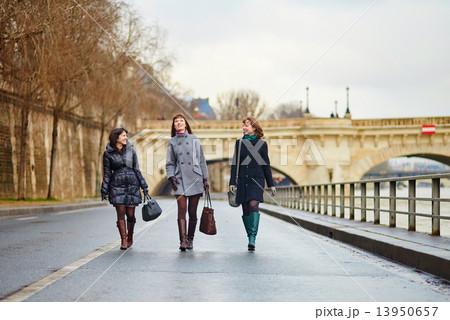 Three cheerful girls walking together in Paris 13950657