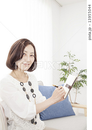 ソファに腰かけるミドルの女性 13955044