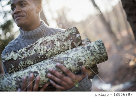 Man carrying firewood in forest in autumn. 13956397