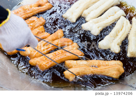 Deep frying bread stick or popularly known as You Tiao, a popular Chinese delicacy. 13974206