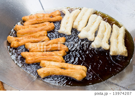 Deep frying bread stick or popularly known as You Tiao, a popular Chinese delicacy. 13974207