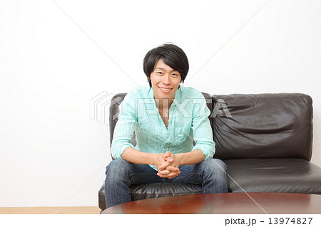 ソファーに座る男性の写真素材