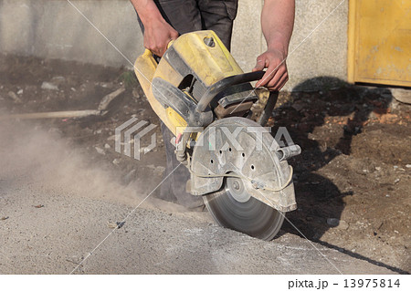 Construction site, worker cut asphalt with saw blade toll 13975814