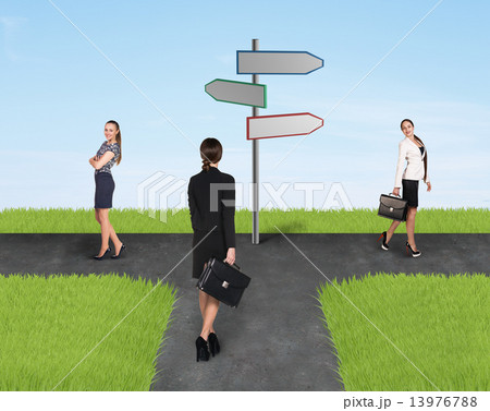 Three usinesswomen standing near sign  13976788
