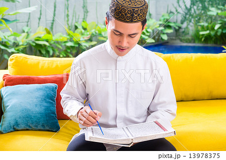 Asian Muslim man reading Koran or Quran Asian Muslim man reading Koran or Quran 13978375
