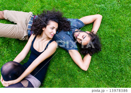 Latin Couple on meadow sleeping in summer 13978386