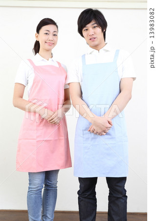エプロンをした若い男性と女性 13983082