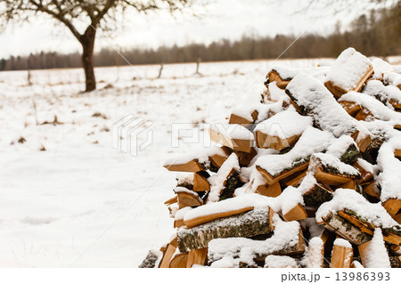 Stacked chopped firewood covered by snow Stacked chopped firewood covered by snow 13986393