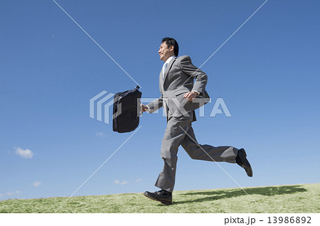 走るスーツの男性の写真素材