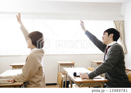 手を挙げる学生の写真素材