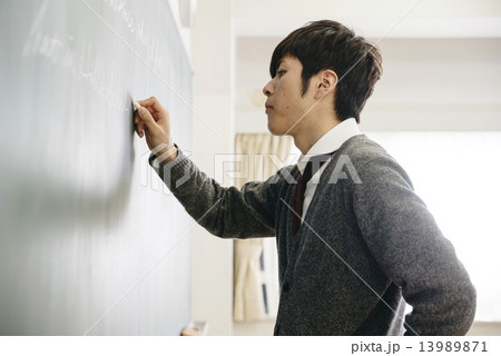 黒板に書く男子学生の写真素材