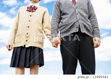 手を繋ぐ学生カップルの写真素材