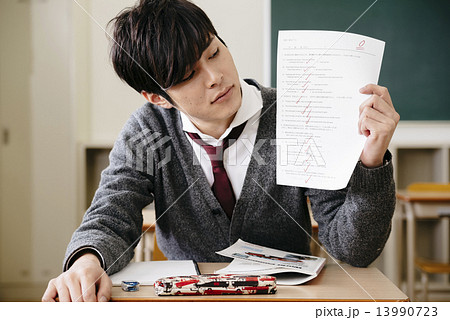 0点のテスト用紙を持つ男子学生 0点のテスト用紙を持つ男子学生 13990723