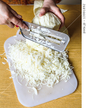 woman chopping cabbage on cutting board woman chopping cabbage on cutting board 13991892