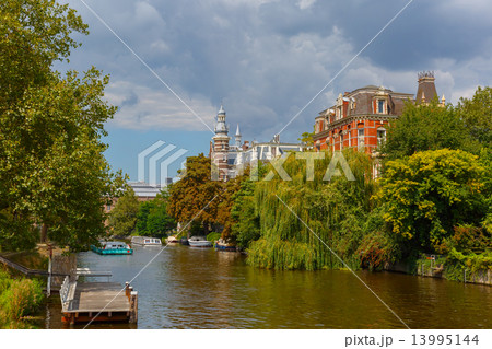 City view of Amsterdam canal, jetty and boat, Holland, Netherlan City view of Amsterdam canal, jetty and boat, Holland, Netherlan 13995144