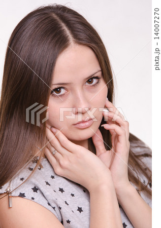 Portrait of a sad girl holding face with hands 14007270