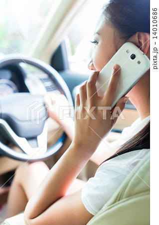 Asian woman using phone driving car Asian woman using phone driving car 14010686