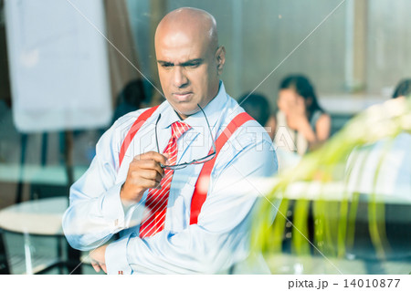Indian Businessman thinking at office window Indian Businessman thinking at office window 14010877